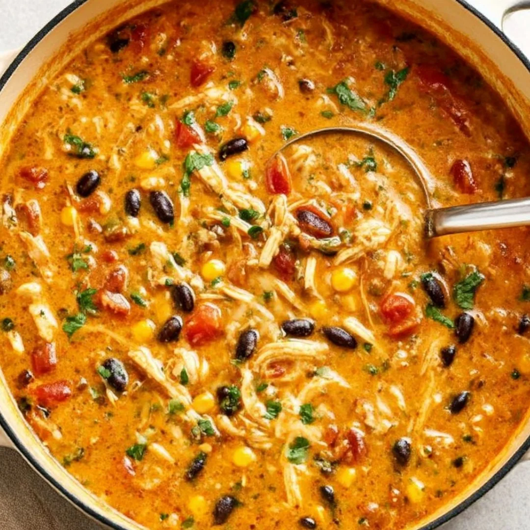 Bowl of creamy chicken tortilla soup topped with avocado and tortilla strips