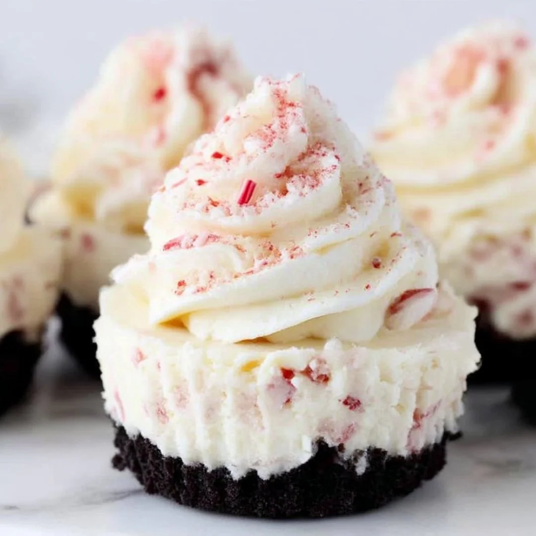 Delicious peppermint cheesecakes topped with whipped cream and candy cane pieces