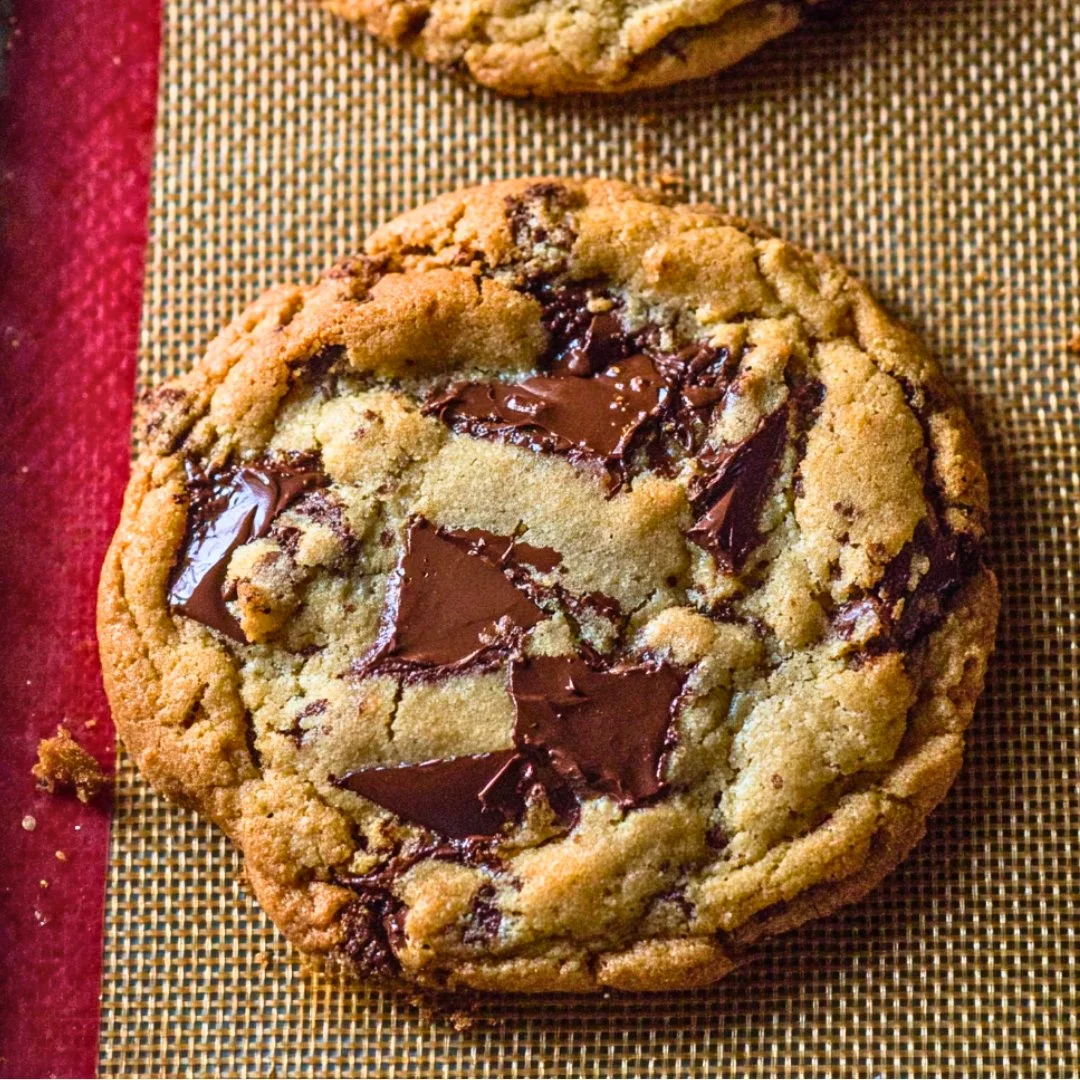 A bright, fizzy blue beverage with granulated salt crystals and a clear jar on a granite surface.