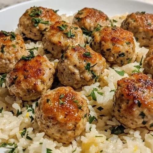 Plate of Greek Turkey Meatballs with Lemon Herb Rice garnished with herbs