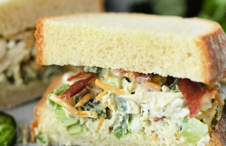 A bright, fizzy blue beverage with granulated salt crystals and a clear jar on a granite surface.