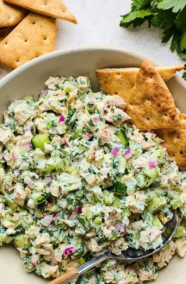 A bright, fizzy blue beverage with granulated salt crystals and a clear jar on a granite surface.